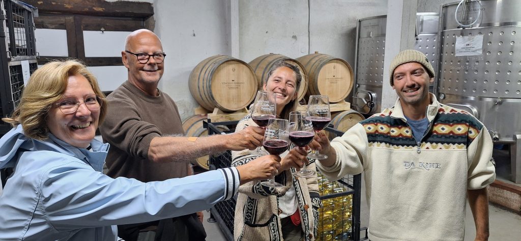 Visitantes Holandeses brindando con vino junto a las barricas de Bodega Vínculo Serrano